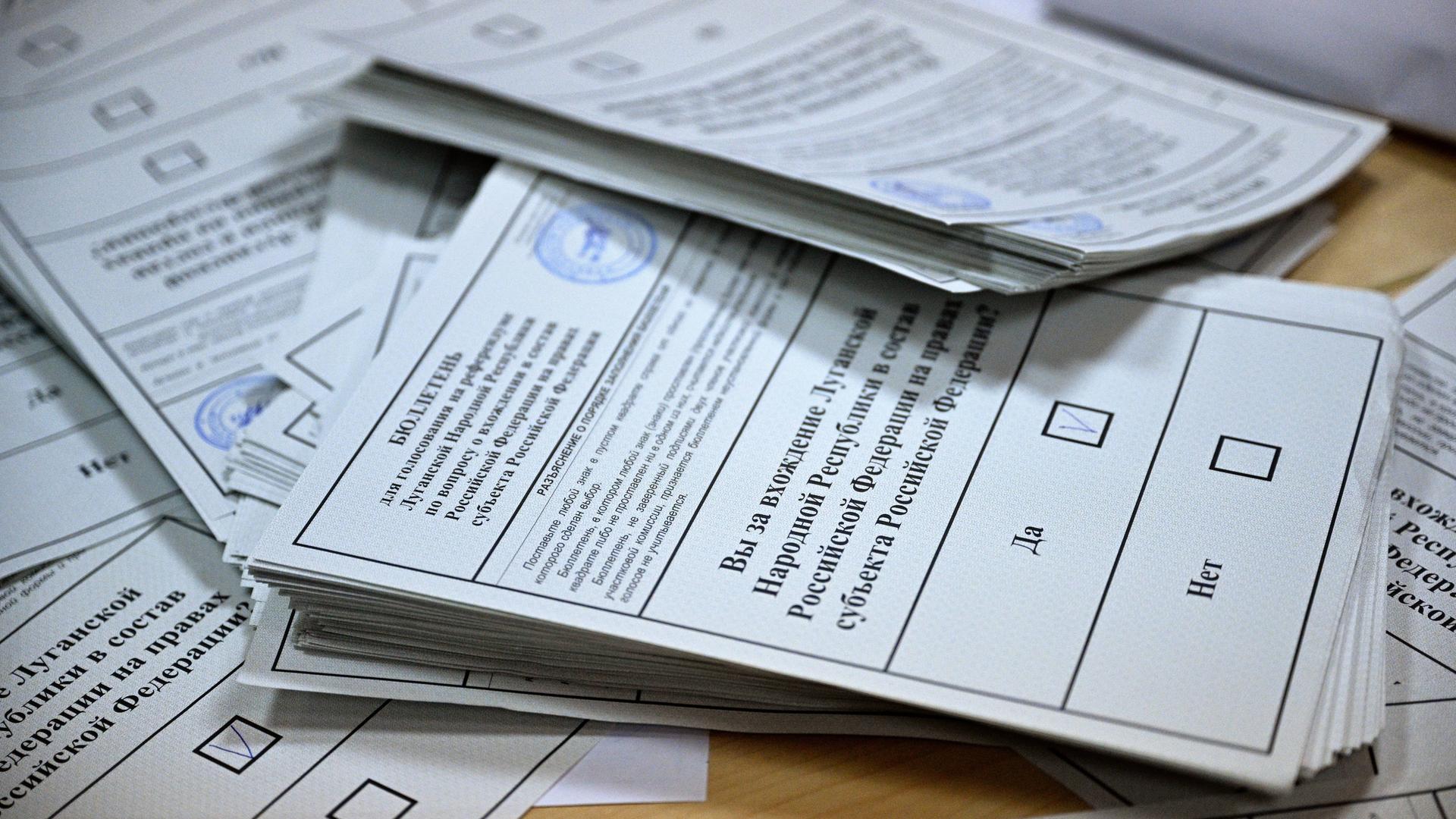 Ausgefüllte Wahlzettel zum Ukraine-Referendum vom 27.09.2022 stapeln sich auf einem Tisch.