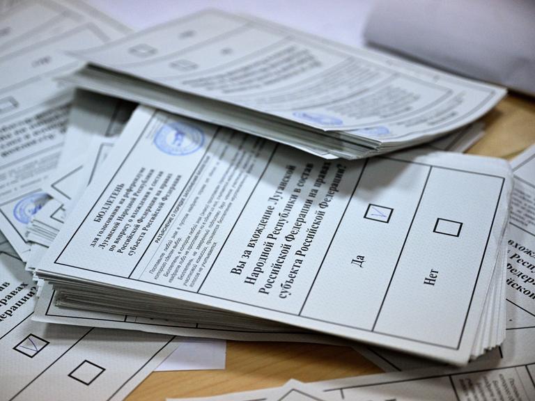 Ausgefüllte Wahlzettel zum Ukraine-Referendum vom 27.09.2022 stapeln sich auf einem Tisch.