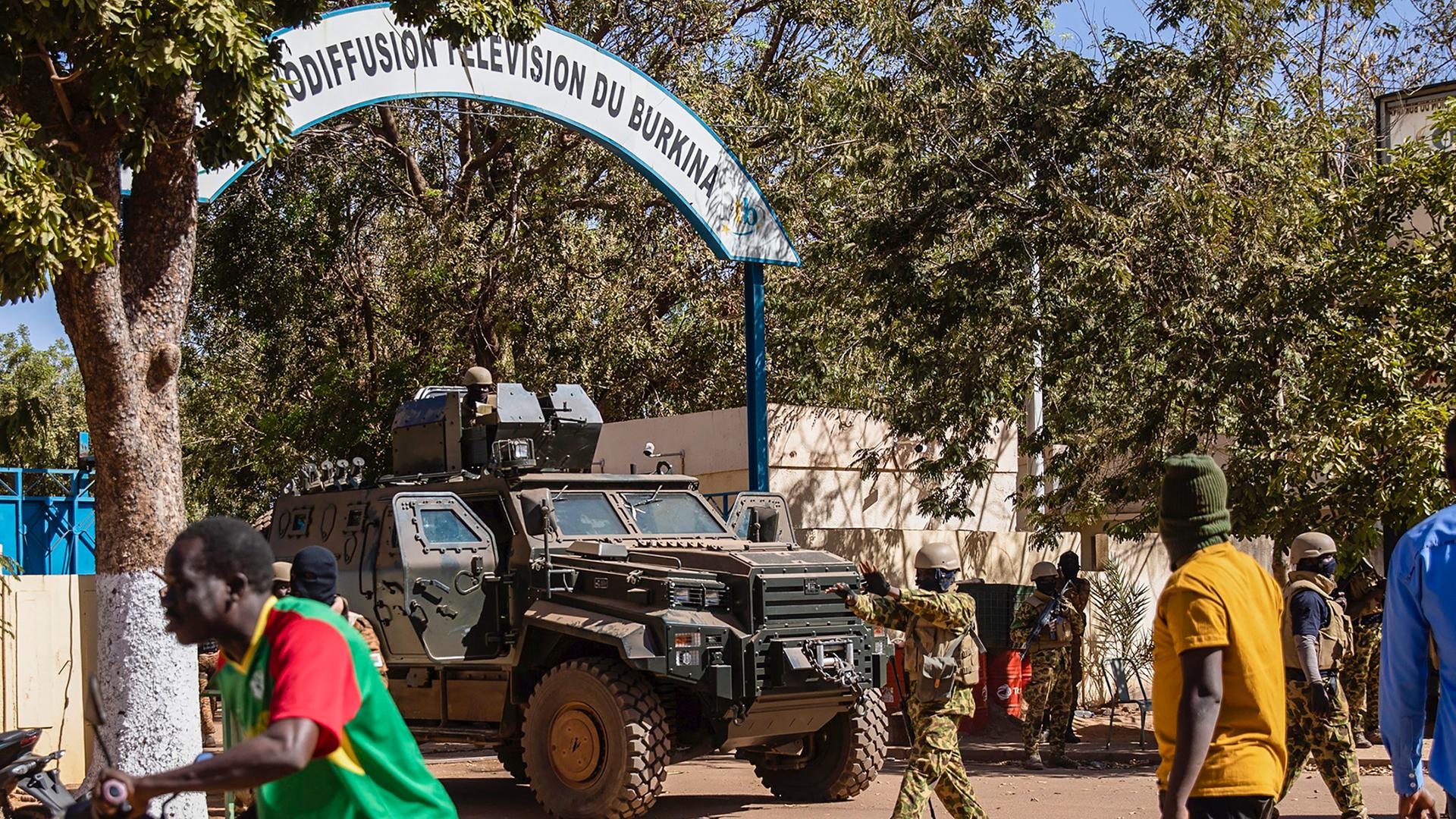 Soldaten in einem Militärfahrzeug stehen vor dem Eingang einer TV-Station in Ouagadougou, Burkina Faso.
