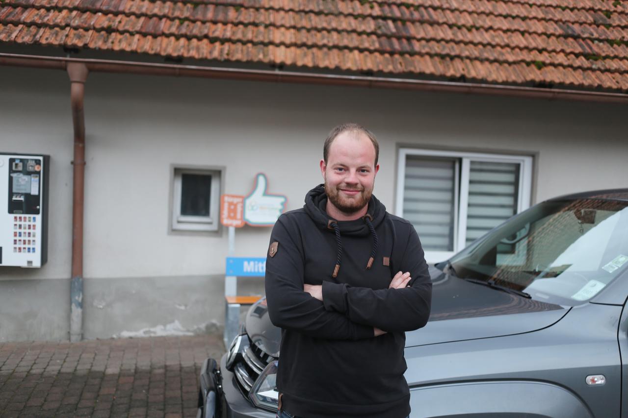 Ein junger Mann steht an ein Pickup angelehnt und schaut in die Kamera. Ein junger Mann steht an ein Pickup angelehnt und schaut in die Kamera.