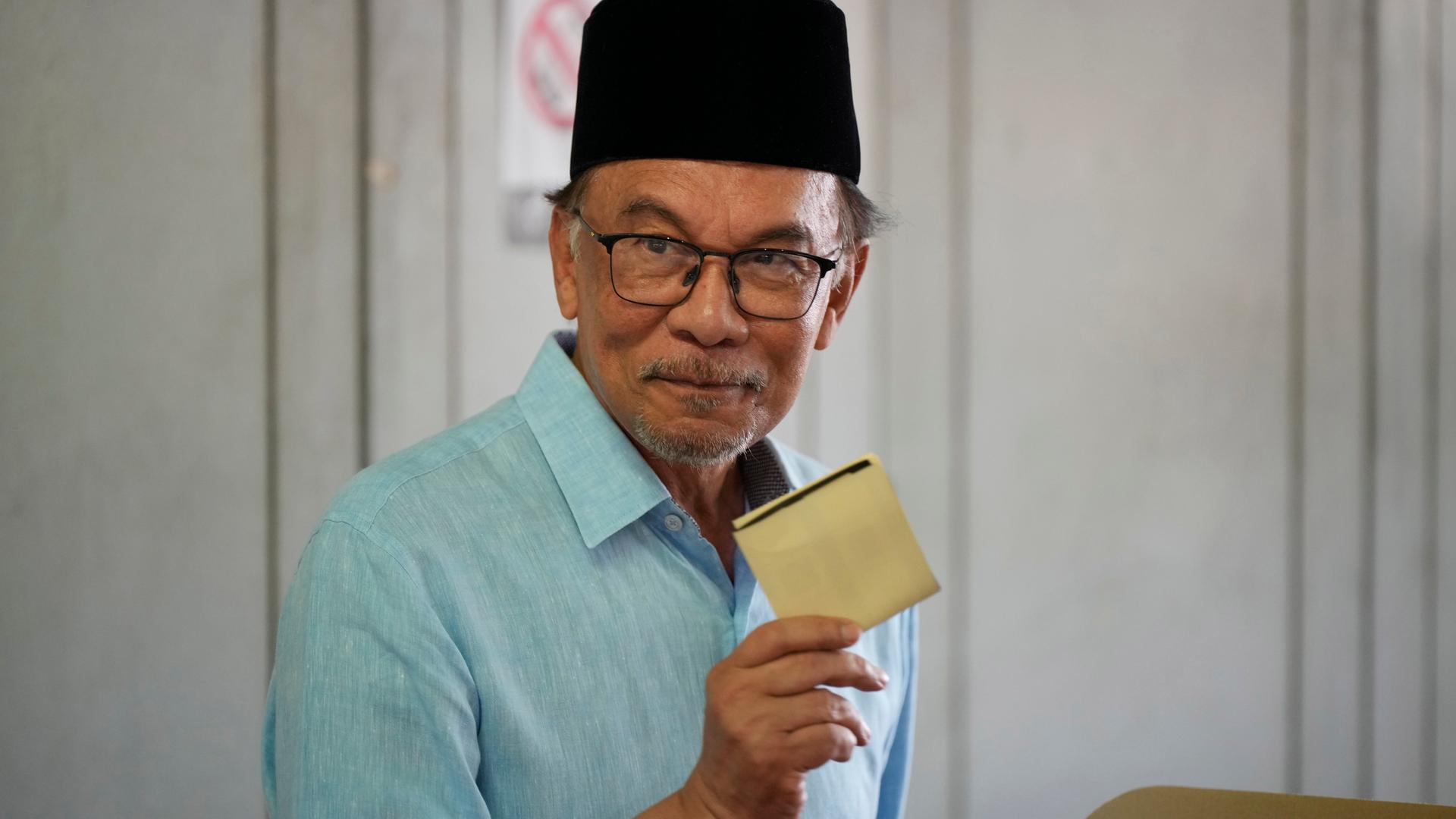 Anwar Ibrahim winkt mit einem Wörterbuch in die Kamera. Anwar Ibrahim winkt mit einem Wörterbuch in die Kamera.