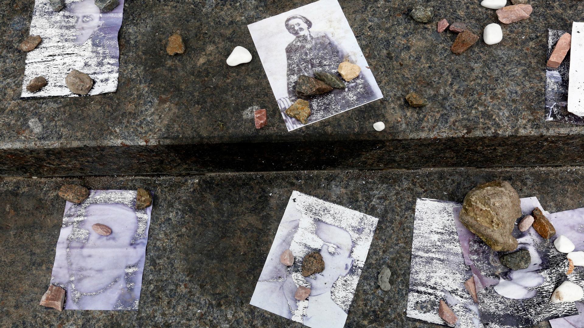 Kleine Steine liegen einer jüdischen Tradition entsprechend auf alten Fotos, die Opfer des Massakers in Babyn Jar 1941 zeigen. Kleine Steine liegen einer jüdischen Tradition entsprechend auf alten Fotos, die Opfer des Massakers in Babyn Jar 1941 zeigen.