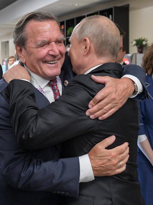 Altkanzler Gerhard Schröder umarmt Russlands Präsident Wladimir Putin (r.) 