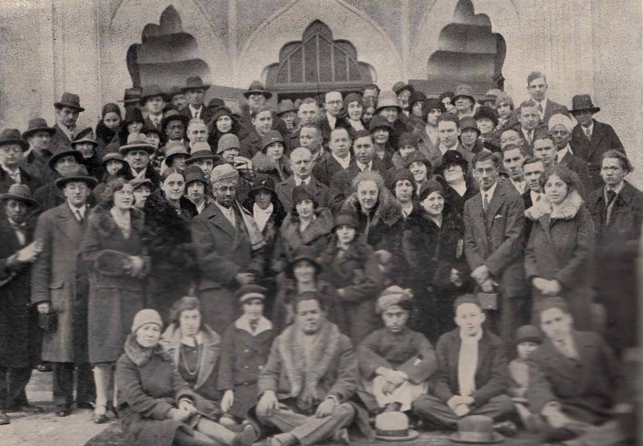 Gruppenbild auf einer Treppe: Die meisten Frauen und Männer tragen Hut oder Turban. Gruppenbild auf einer Treppe: Die meisten Frauen und Männer tragen Hut oder Turban.