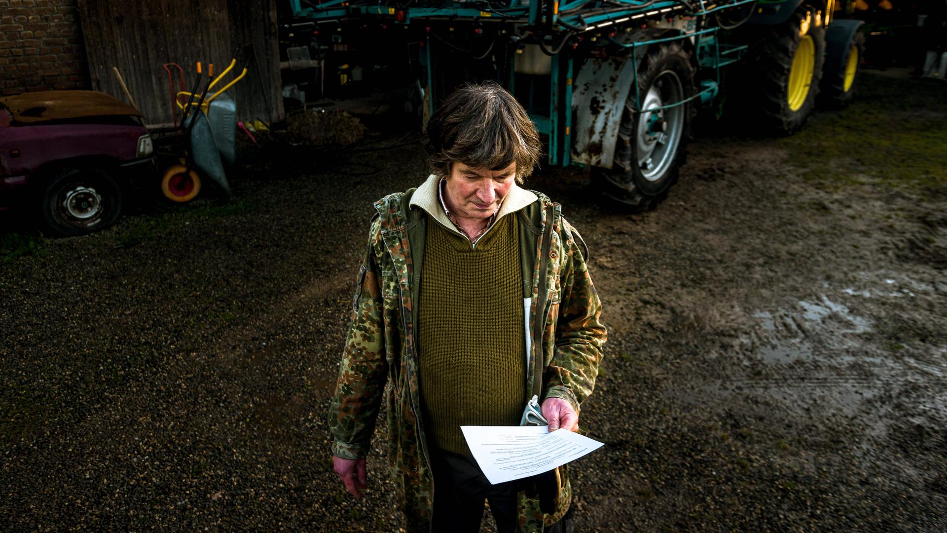 Eckhardt Heukamp vor einem Traktor mit einem Brief in der Hand Eckhardt Heukamp vor einem Traktor mit einem Brief in der Hand