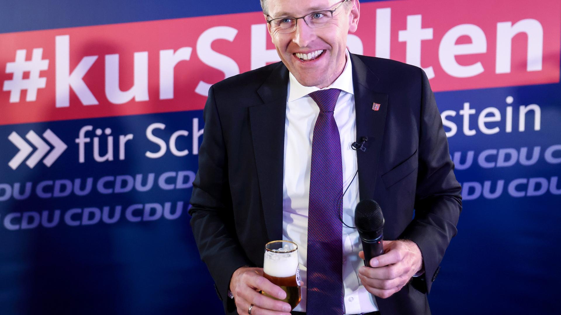 Daniel Günther (CDU), Ministerpräsident von Schleswig-Holstein und Spitzenkandidat seiner Partei, steht bei der Wahlparty mit einem alkoholfreien Bier auf der Bühne. Daniel Günther (CDU), Ministerpräsident von Schleswig-Holstein und Spitzenkandidat seiner Partei, steht bei der Wahlparty mit einem alkoholfreien Bier auf der Bühne.