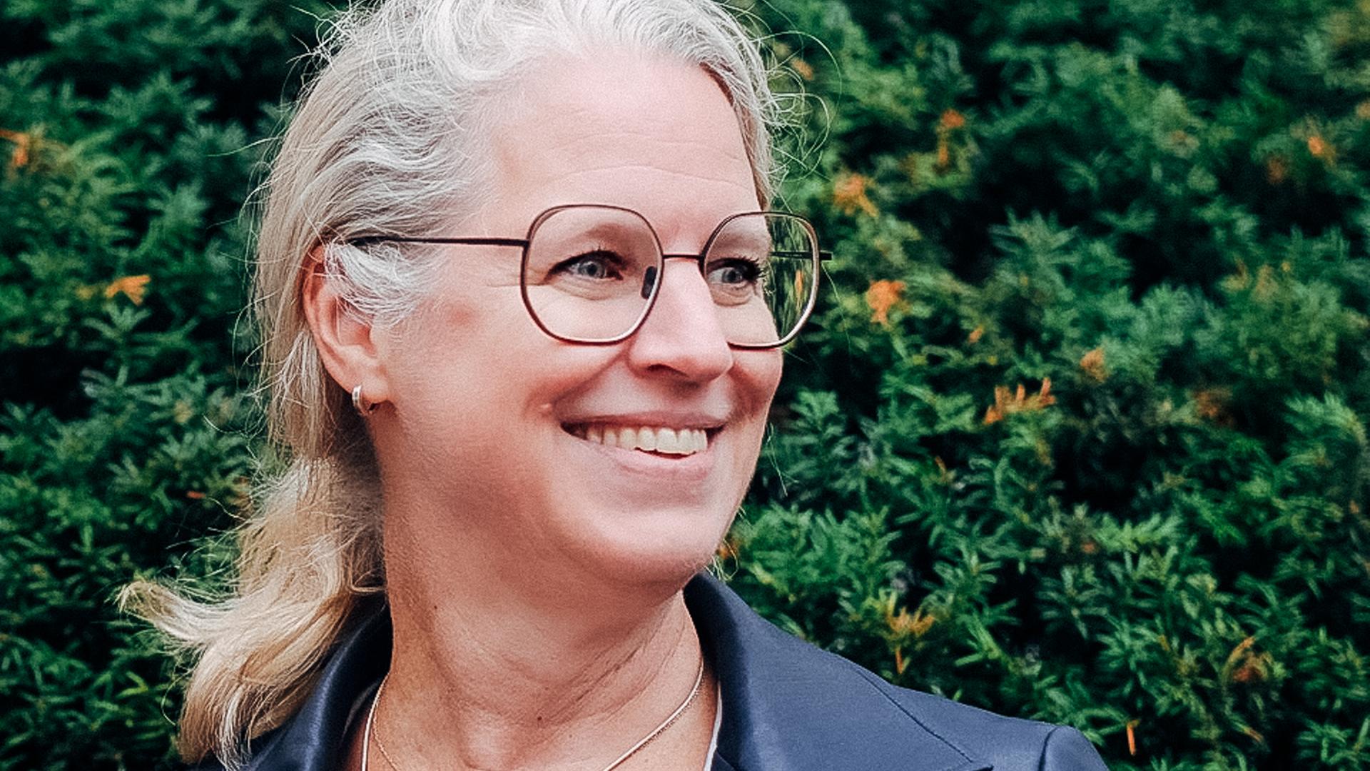 Isabel Bogdan vor einer grünen Hecke Isabel Bogdan vor einer grünen Hecke