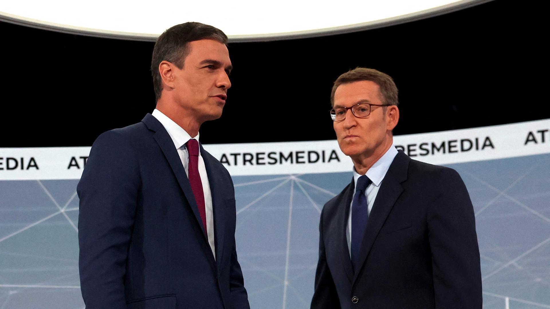 Zu sehen sind Spaniens derzeitiger Minsterpräsident Sanchez, links und der konservative Oppositionsführer Feijóo in einem Fernsehstudio.