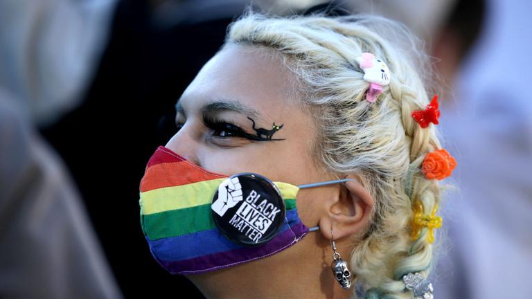 BOSTON, MA - OCTOBER 17: A protester wearing a rainbow mask and a Black Lives Matter pin joins roughly 1,000 demonstrators as they take over the streets around Boston Common in a show of resistance to President Trump in Boston on Oct. 17, 2020. The demonstrations were planned by the Womens March organization that staged marches around the world the day after Trumps inauguration to protest the confirmation of Supreme Court nominee Amy Coney Barrett and to rally voter opposition to Trumps reelection. (Photo by Jonathan Wiggs/The Boston Globe via Getty Images)