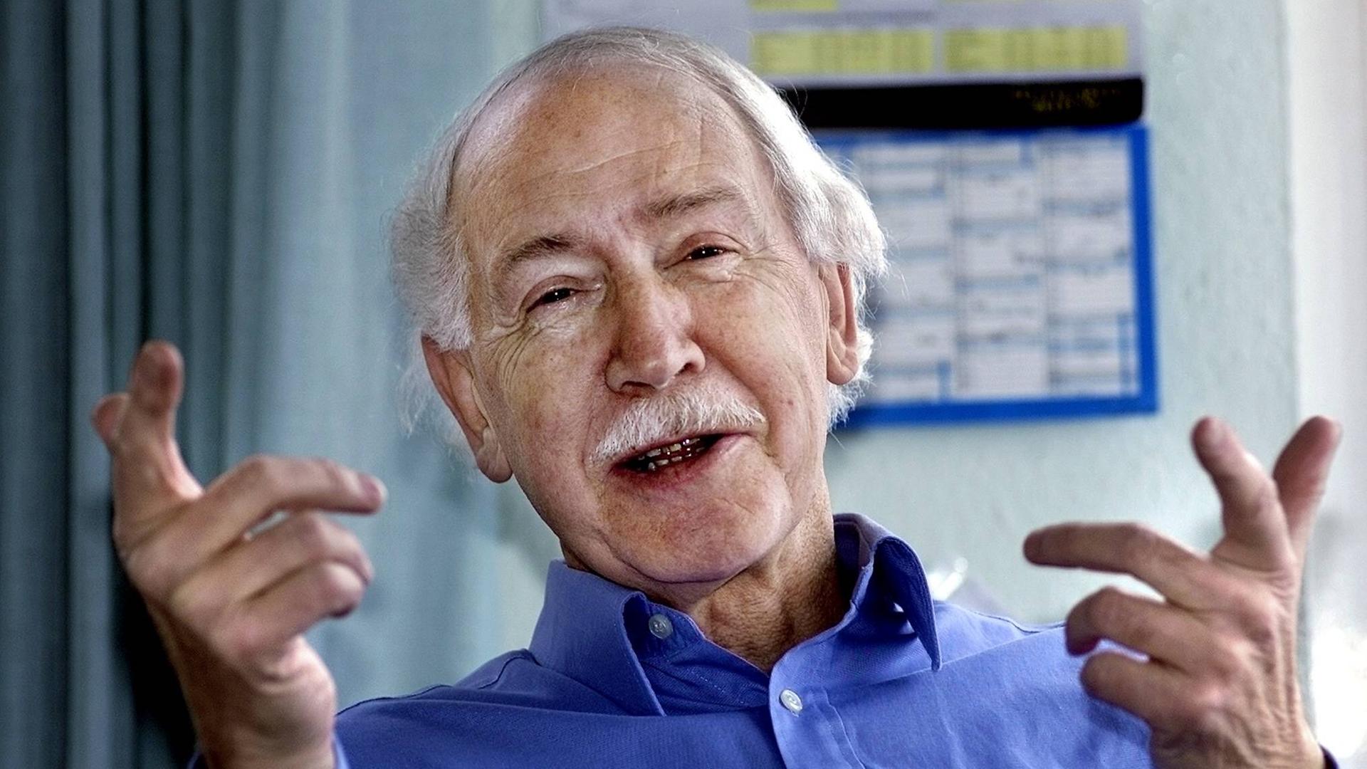 Hermann Bausinger lächelnd und fröhlich gestikulierend. Hermann Bausinger lächelnd und fröhlich gestikulierend.