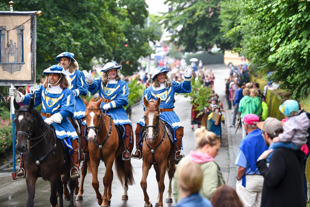 Reiter in historischen Kostümen führen den Festumzug des Rutenfestes durch die Innenstadt an. 