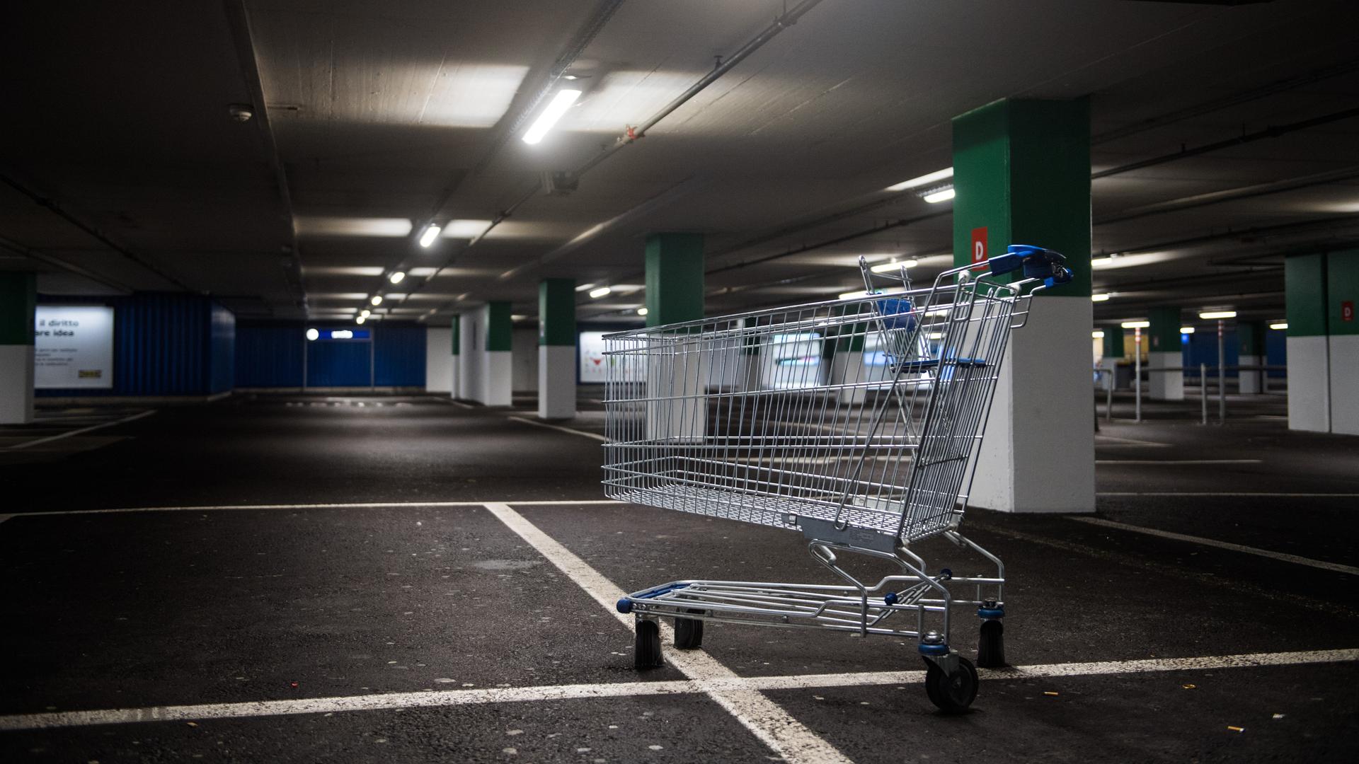 Ein Einkaufswagen steht im leeren Parkhaus Ein Einkaufswagen steht im leeren Parkhaus