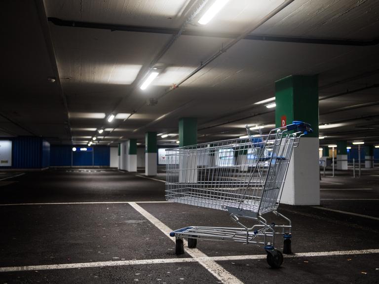 Ein Einkaufswagen steht im leeren Parkhaus