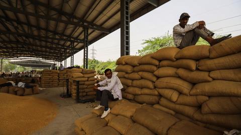Arbeiter sitzen in Indien auf Reissäcken