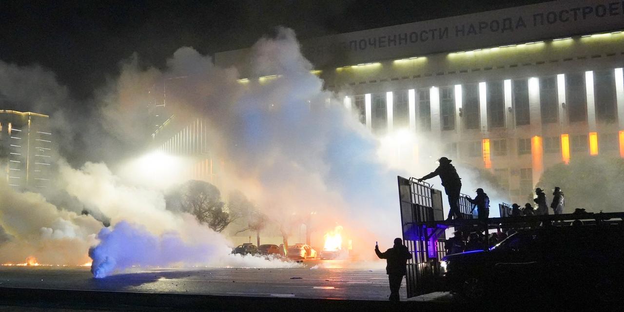 Bereitschaftspolizisten hinter einer Absperrung in Kasachstan, auf der Straße sind Blendgranaten zu sehen. Bereitschaftspolizisten hinter einer Absperrung in Kasachstan, auf der Straße sind Blendgranaten zu sehen.