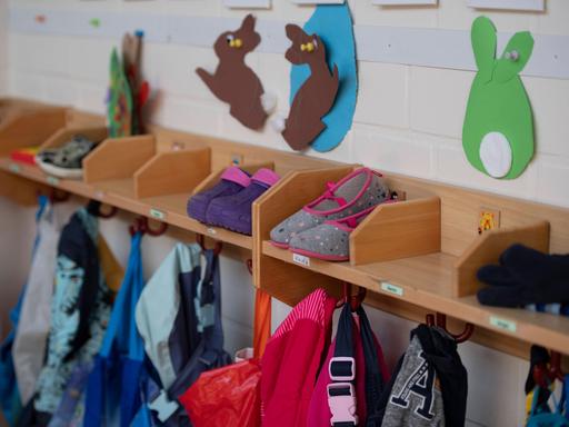 Garderobe mit Schuhen, Jacken und gebastelten Osterhasen in einem Kindergarten.
