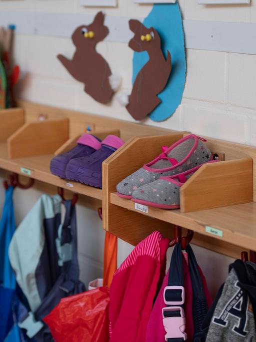 Garderobe mit Schuhen, Jacken und gebastelten Osterhasen in einem Kindergarten.