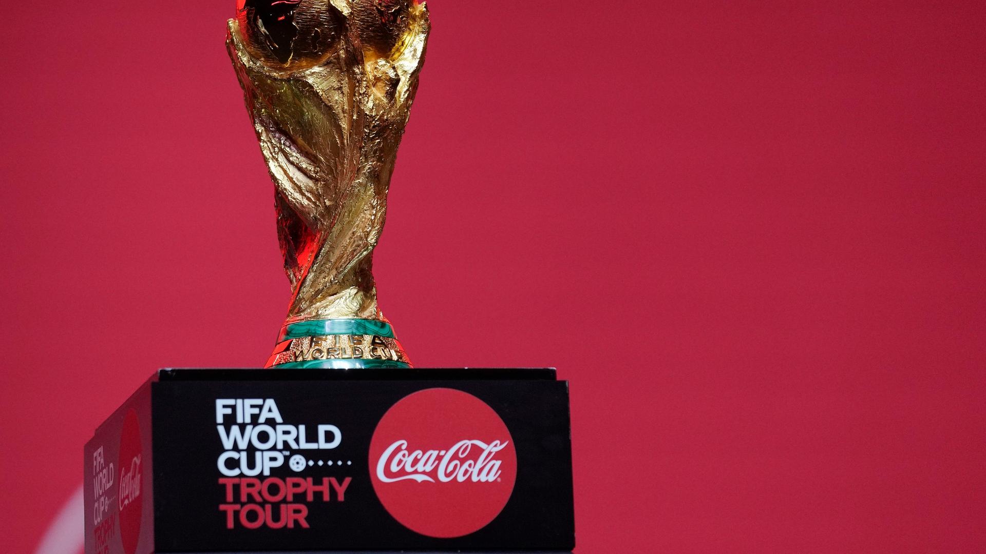 Der Pokal der FIFA Weltmeisterschaft steht auf einem Sockel mit einem Logo des Getränkeherstellers Coca Cola.