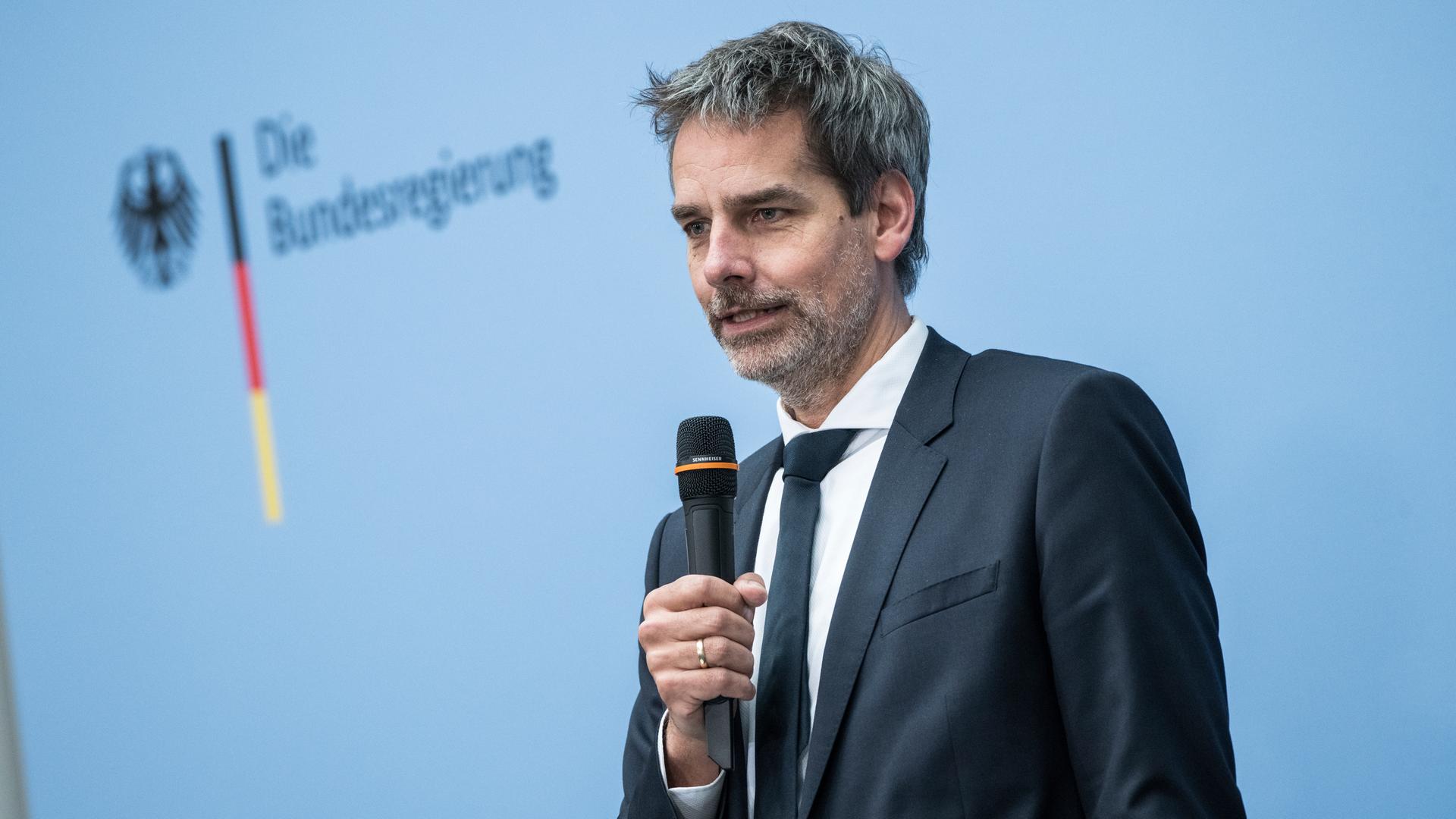 Regierungssprecher Steffen Hebestreit spricht in ein Mikrofon, hinter ihm ist ein Logo der Bundesregierung zu sehen.