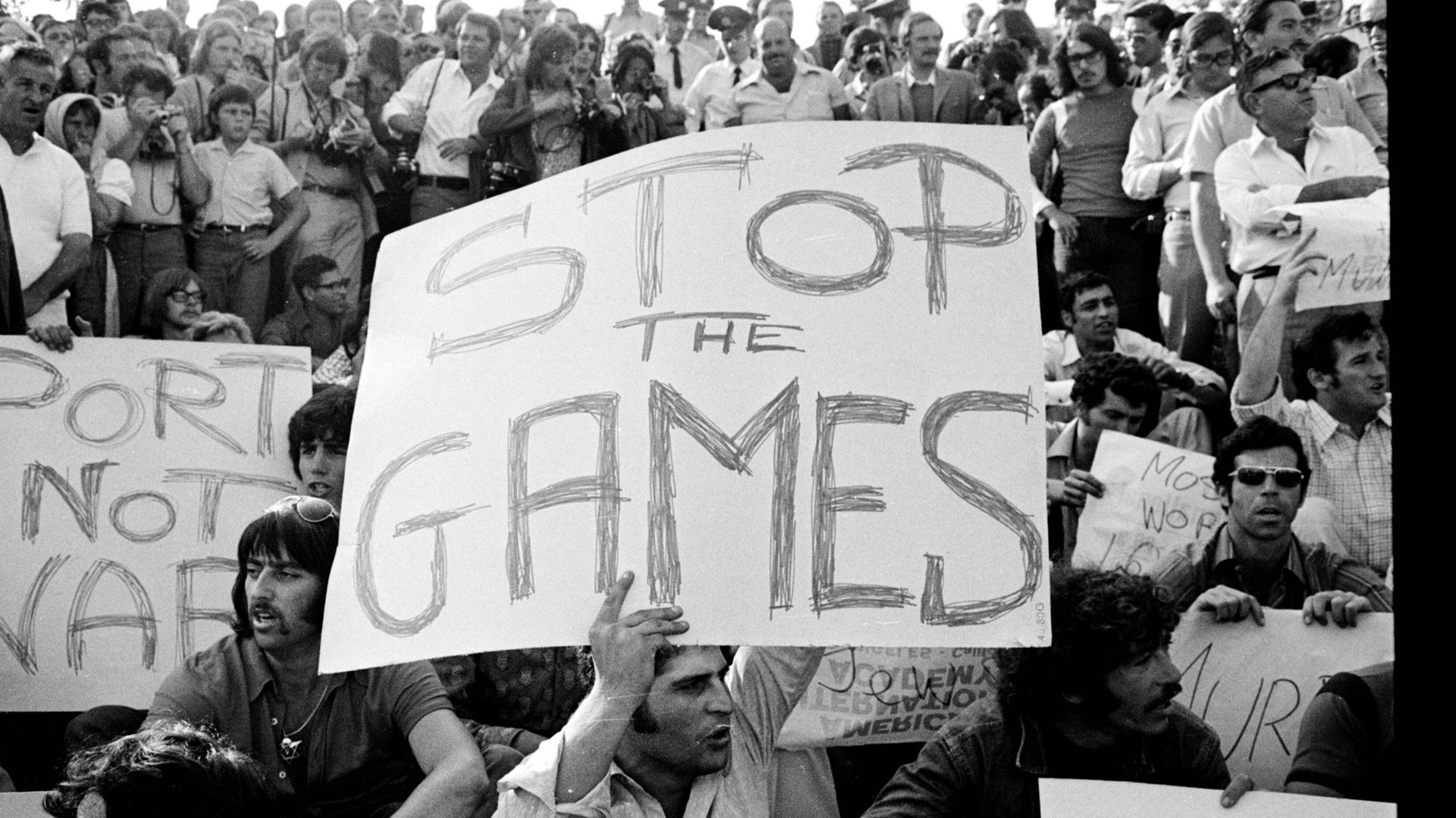 Auf Plakaten bei den Olympischen Spielen 1972 Protestierende das Ende der Spiele wegen des Attentats auf das Team Israel. 
