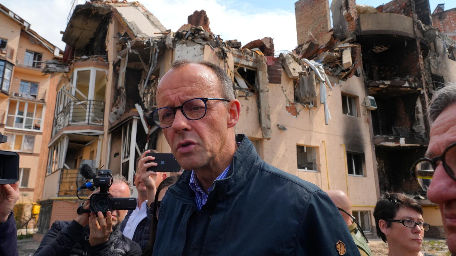 Friedrich Merz und Journalisten gehen durch die zerstörte Stadt Irpin. Friedrich Merz und Journalisten gehen durch die zerstörte Stadt Irpin.