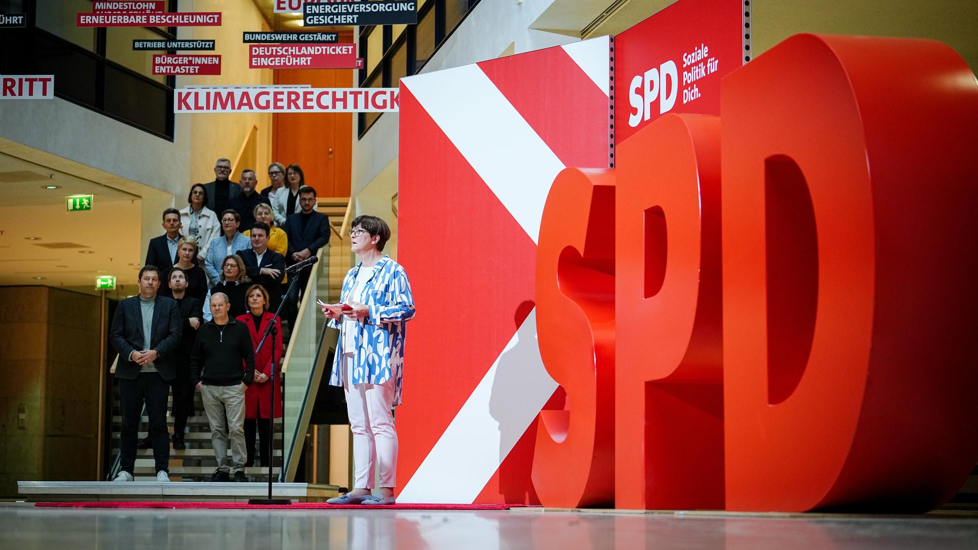 Eine Frau hält eine Rede, auf der rechten Seite stehen großen rote Buchstaben: SPD Eine Frau hält eine Rede, auf der rechten Seite stehen großen rote Buchstaben: SPD