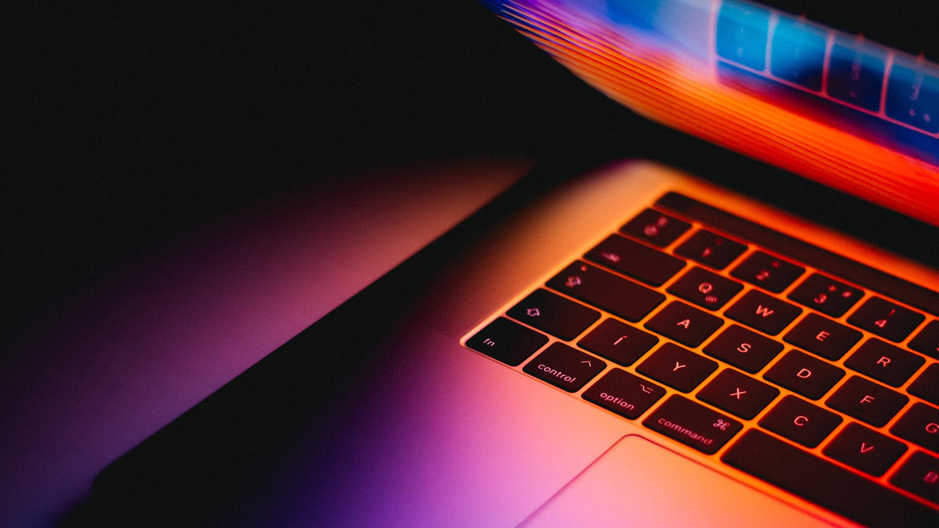 Laptop im Dunkeln mit leuchtendem Bildschirm Laptop im Dunkeln mit leuchtendem Bildschirm