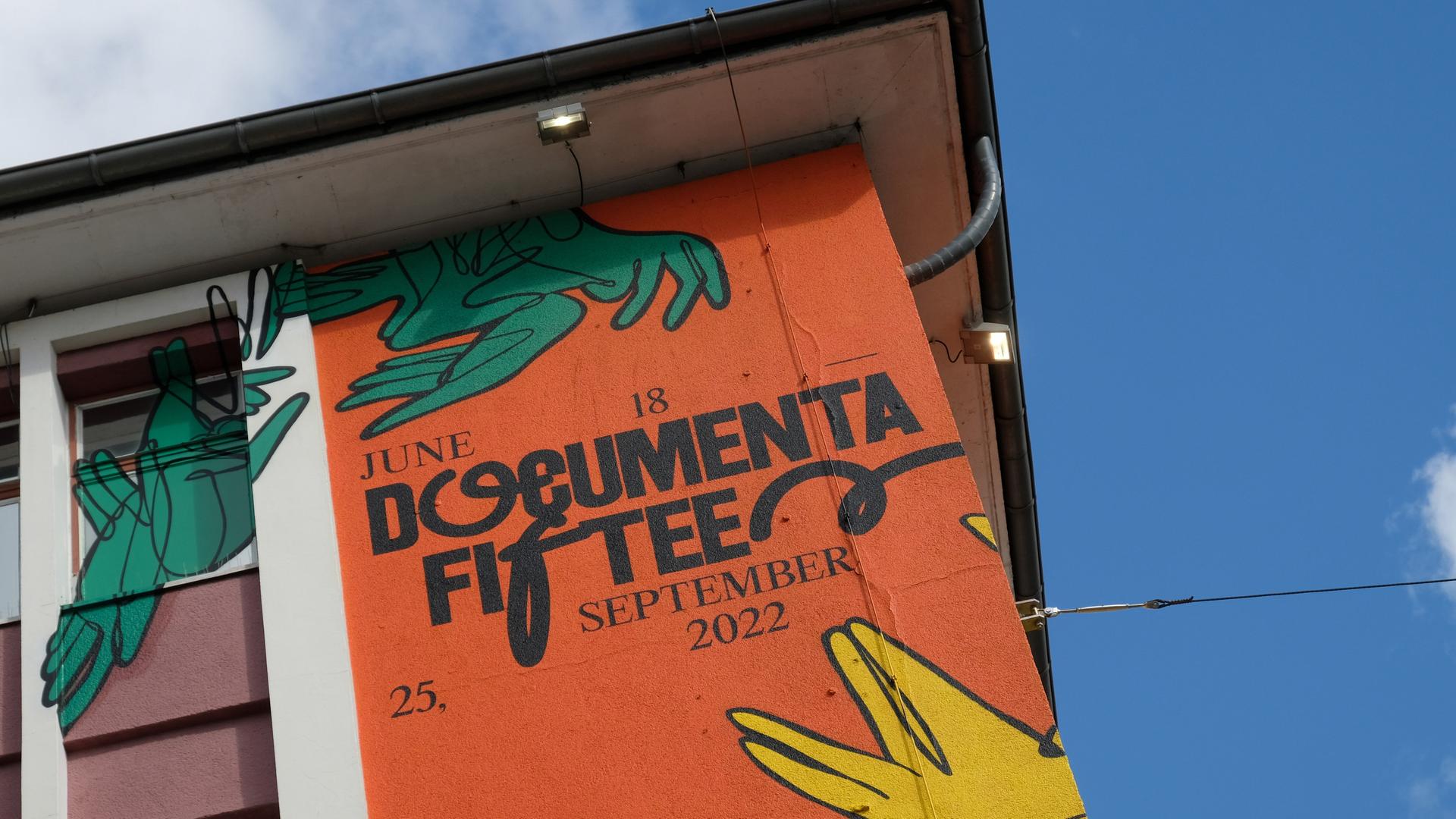 Der Schriftzug "documenta fifteen" und das Logo vom indonesischen Kuratorenkollektiv Ruangrupa prangt an der Fassade eines ehemaligen Sportgeschäftes in der Kasseler Innenstadt. Der Schriftzug "documenta fifteen" und das Logo vom indonesischen Kuratorenkollektiv Ruangrupa prangt an der Fassade eines ehemaligen Sportgeschäftes in der Kasseler Innenstadt.