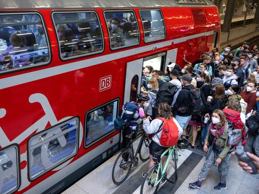 Vor einem Regionalzug am Berliner Hauptbahnhof drängen sich zahlreiche Reisende.