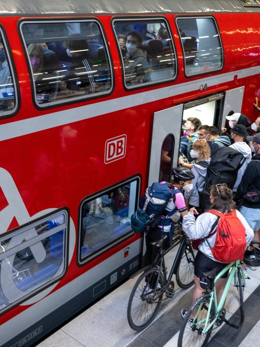 Vor einem Regionalzug am Berliner Hauptbahnhof drängen sich zahlreiche Reisende.