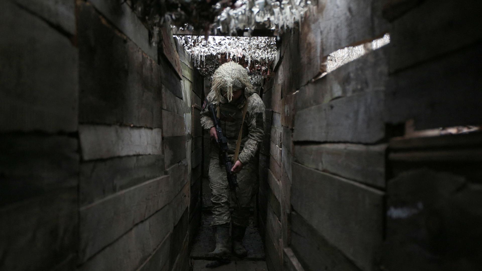 Ein ukrainischer Soldat geht am 10. Dezember 2021 durch einen Graben an der Frontlinie zu von Russland unterstützen Separatisten in Donezk. Ein ukrainischer Soldat geht am 10. Dezember 2021 durch einen Graben an der Frontlinie zu von Russland unterstützen Separatisten in Donezk.