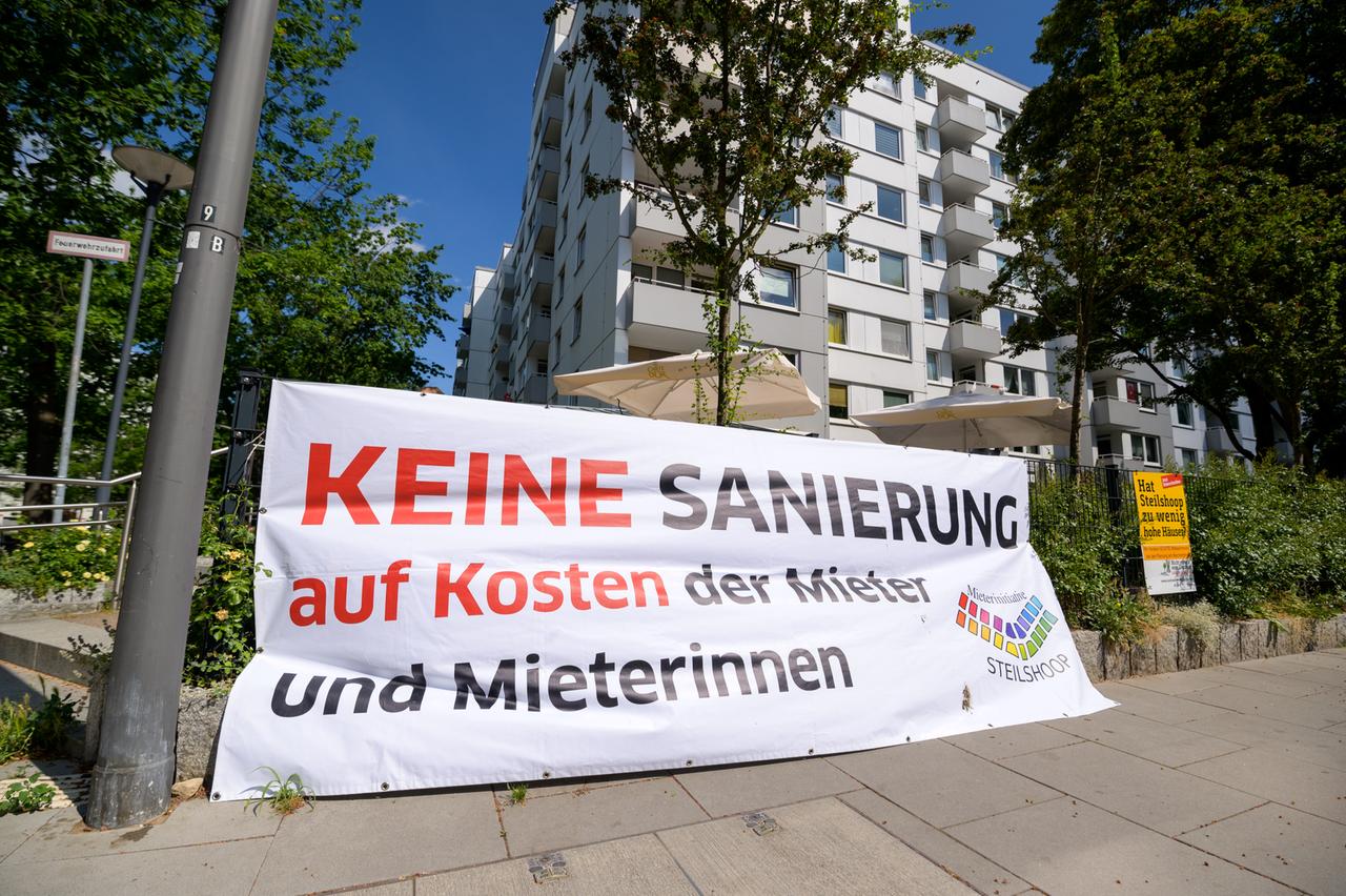Ein Plakat mit der Aufschrift "Keine Sanierung auf Kosten der Mieter und Mieterinnen" vor einem Hochhaus in Hamburg-Steilshoop. Ein Plakat mit der Aufschrift "Keine Sanierung auf Kosten der Mieter und Mieterinnen" vor einem Hochhaus in Hamburg-Steilshoop.