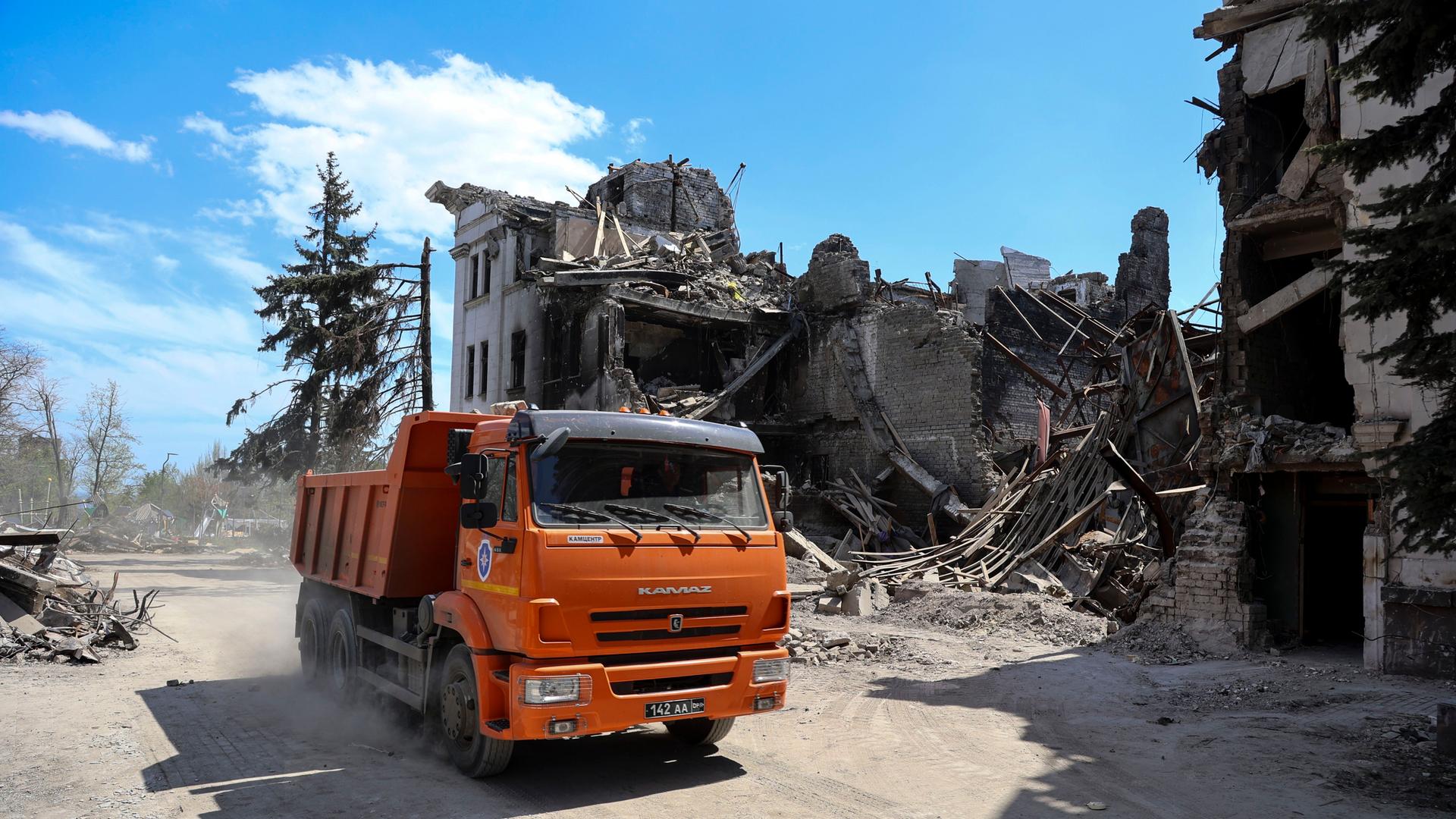 Ukraine, Mariupol: Ein Lastwagen fährt am Theater von Mariupol vorbei, das während der Kämpfe in der Stadt beschädigt wurde. Ukraine, Mariupol: Ein Lastwagen fährt am Theater von Mariupol vorbei, das während der Kämpfe in der Stadt beschädigt wurde.