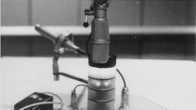 Schwarz-Weiß-Aufnahme zeigt Mikrofon und Kommandofeld eines Sprechertischs beim Deutschlandfunk, 1990 Schwarz-Weiß-Aufnahme zeigt Mikrofon und Kommandofeld eines Sprechertischs beim Deutschlandfunk, 1990