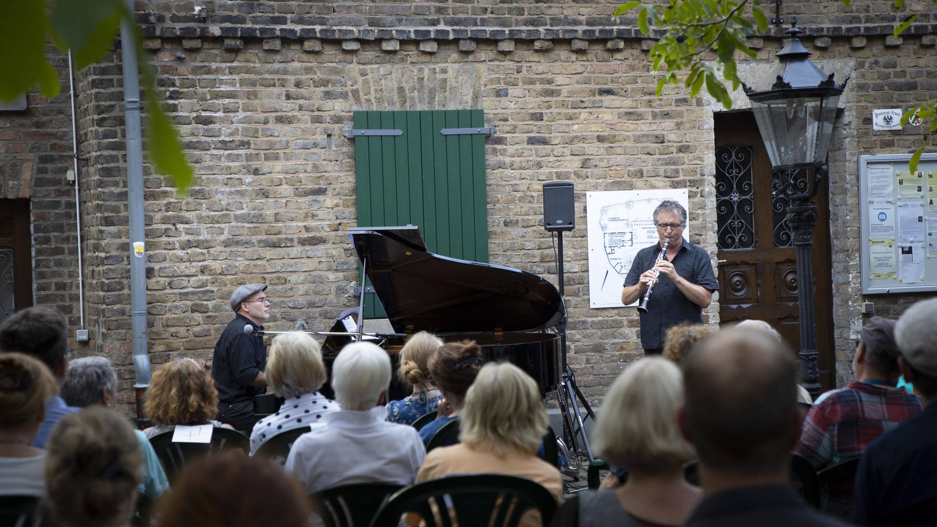 Musiker auf einer Open-Air-Bühne vor Publikum Musiker auf einer Open-Air-Bühne vor Publikum