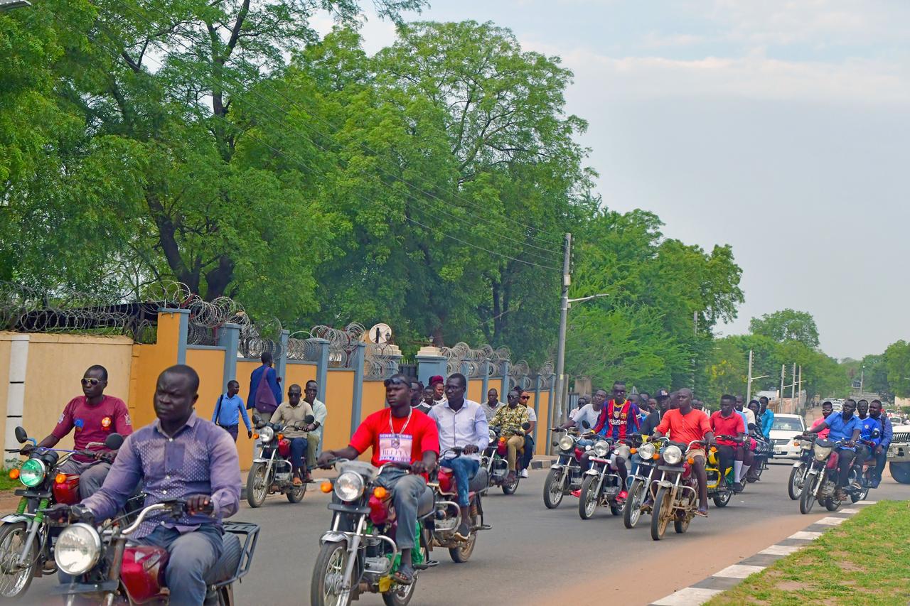 Zahlreiche Motorräder und Mofas fahren über eine Straße in der südsudanesischen Hauptstadt Juba. Zahlreiche Motorräder und Mofas fahren über eine Straße in der südsudanesischen Hauptstadt Juba.