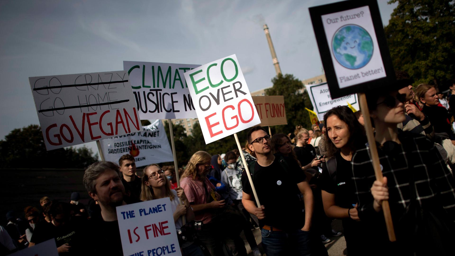 Auf einer Klima-Demonstration hält ein Mann ein kleines Plakat hoch, auf dem steht: Eco statt Ego Auf einer Klima-Demonstration hält ein Mann ein kleines Plakat hoch, auf dem steht: Eco statt Ego