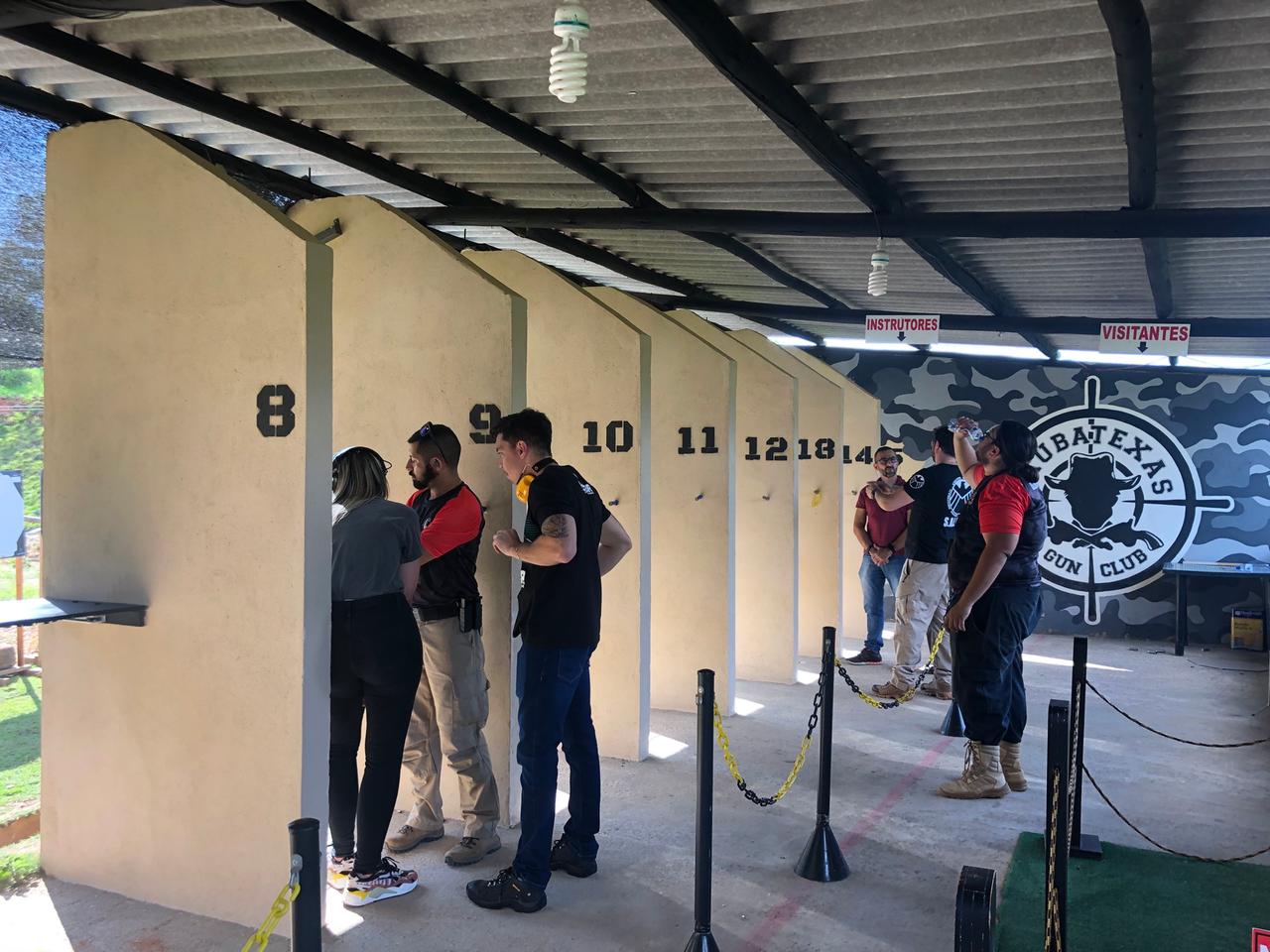 Personengruppen stehen an den Schießständen des Taubatexas Gun Club. Personengruppen stehen an den Schießständen des Taubatexas Gun Club.
