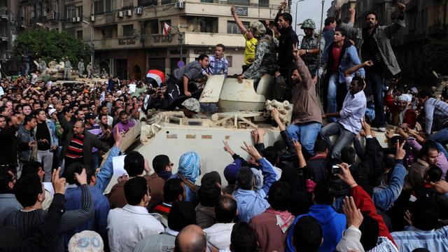 Demonstranten protestieren in Kairo auf dem Tahrir-Platz neben einem Panzer am 29.01.2011.