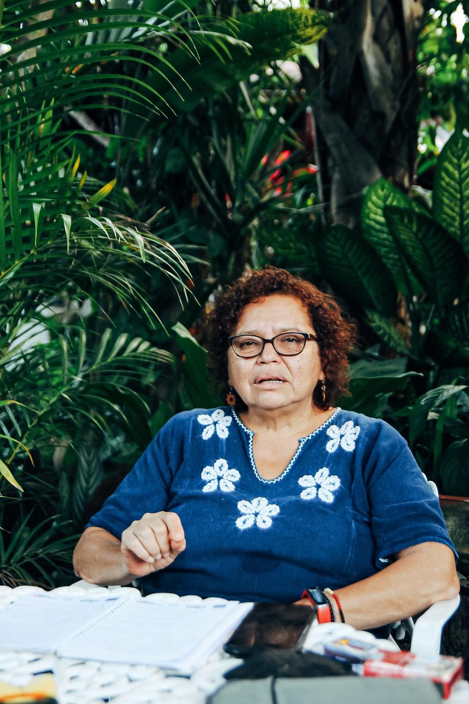 Die Frauenrechtlerin Morena Herrera sitzt an einem Schreibtisch im Garten. Die Frauenrechtlerin Morena Herrera sitzt an einem Schreibtisch im Garten.