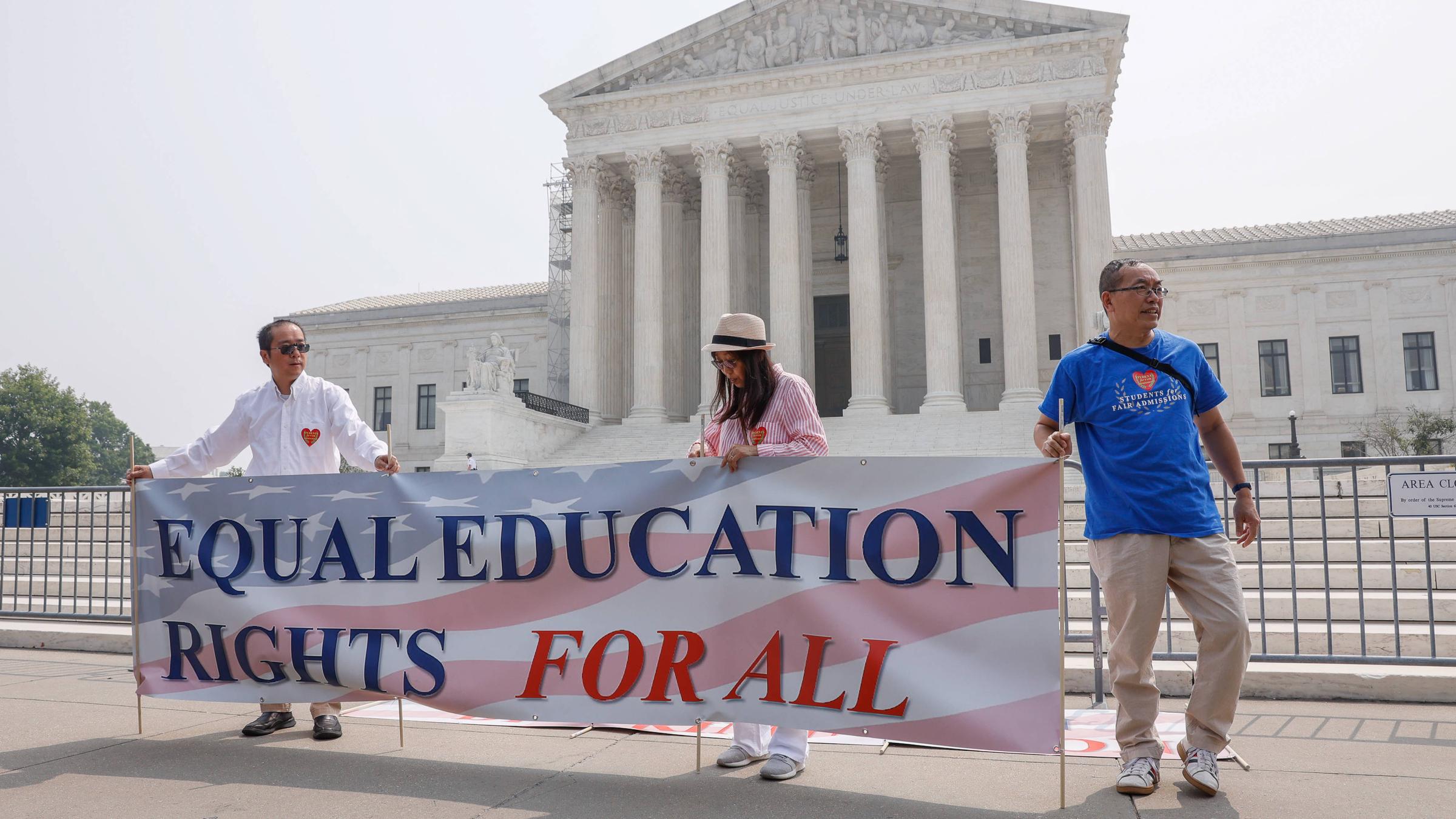 Personen halten ein Banner, auf dem übersetzt steht: „Gleiche Bildungsrechte für alle.“
