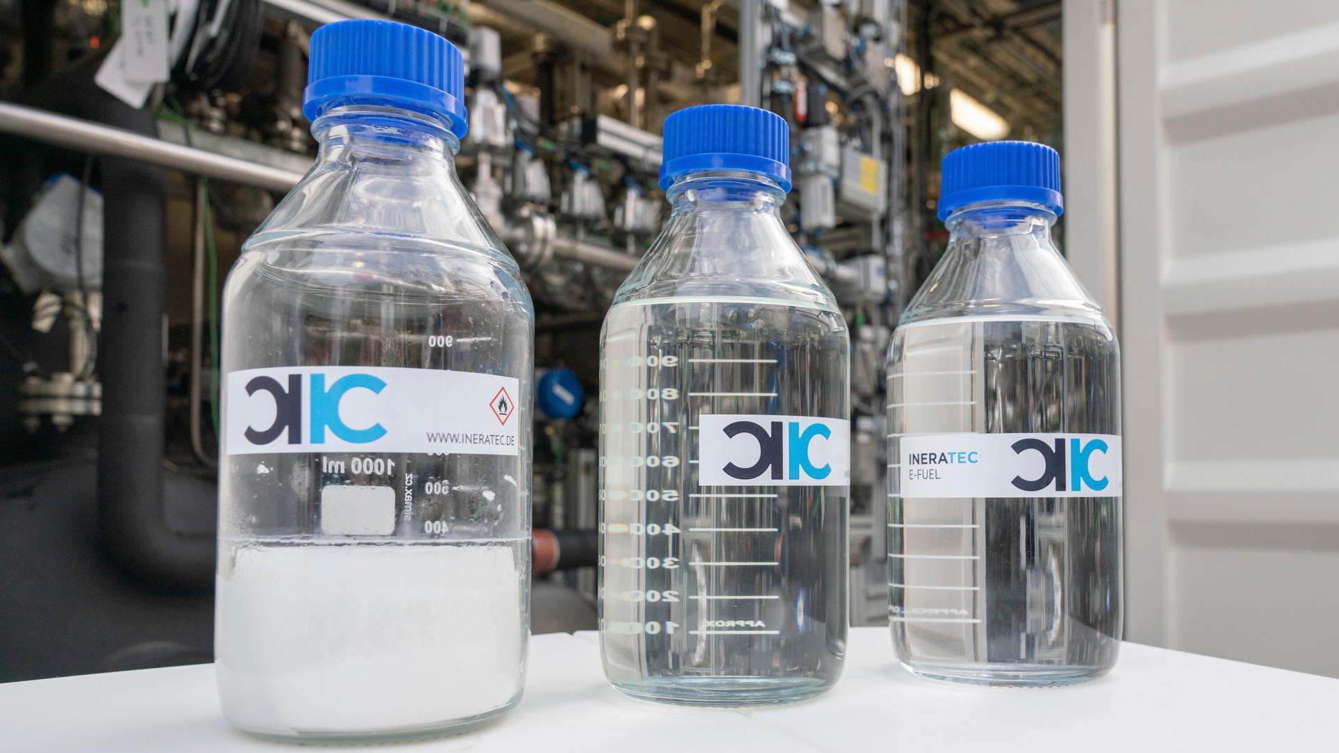 Durchsichtige Flaschen mit blauem Deckel von Ineratec - die Firma stellt nachhaltige Treibstoffe aus dem Klimakiller CO2 und grünem Wasserstoff her
