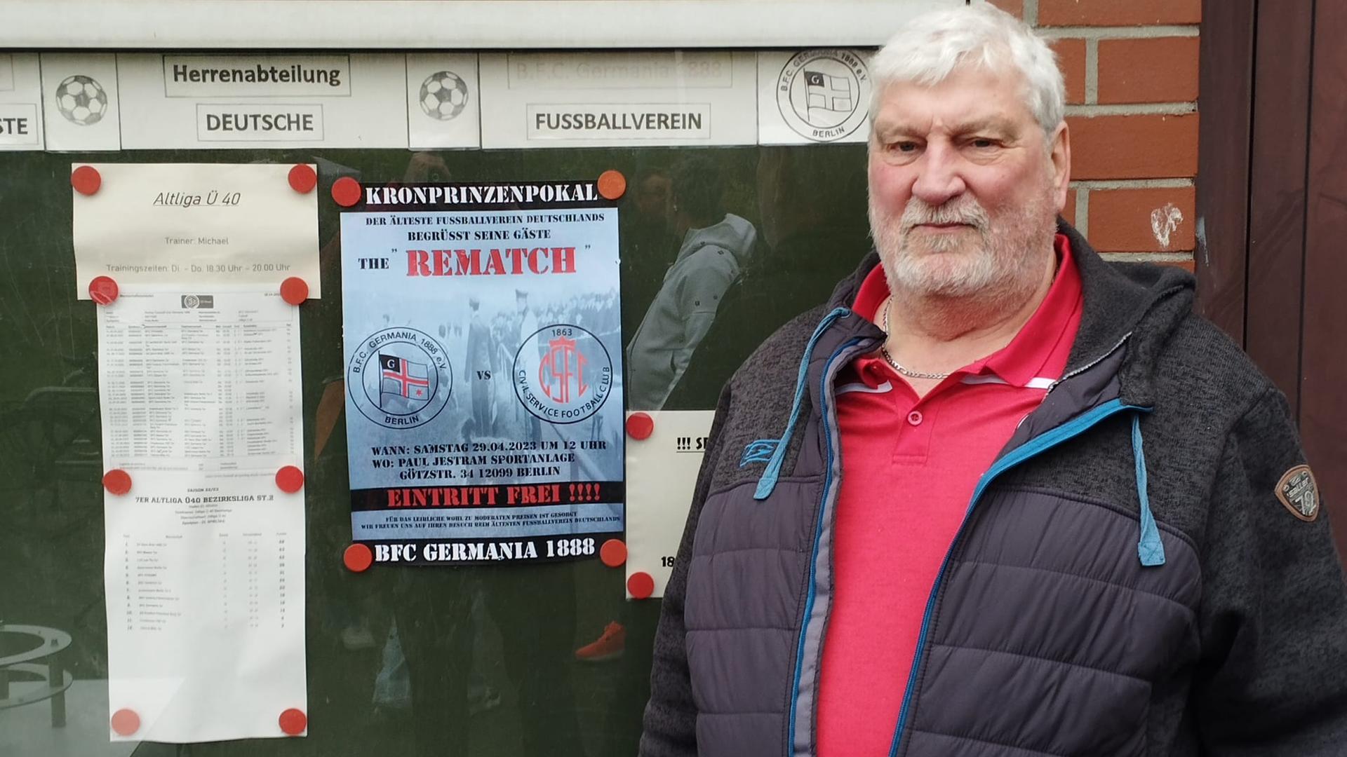 Heinz-Dietrich Kraschewski steht vor dem Plakat für das Spiel gegen Civil Service.
