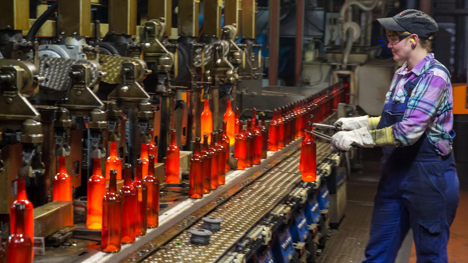 Eine Mitarbeiterin entnimmt in Grossbreitenbach (Thüringen) eine Flasche aus der Glasproduktion bei Wiegand-Glas zur Gewichtskontrolle.