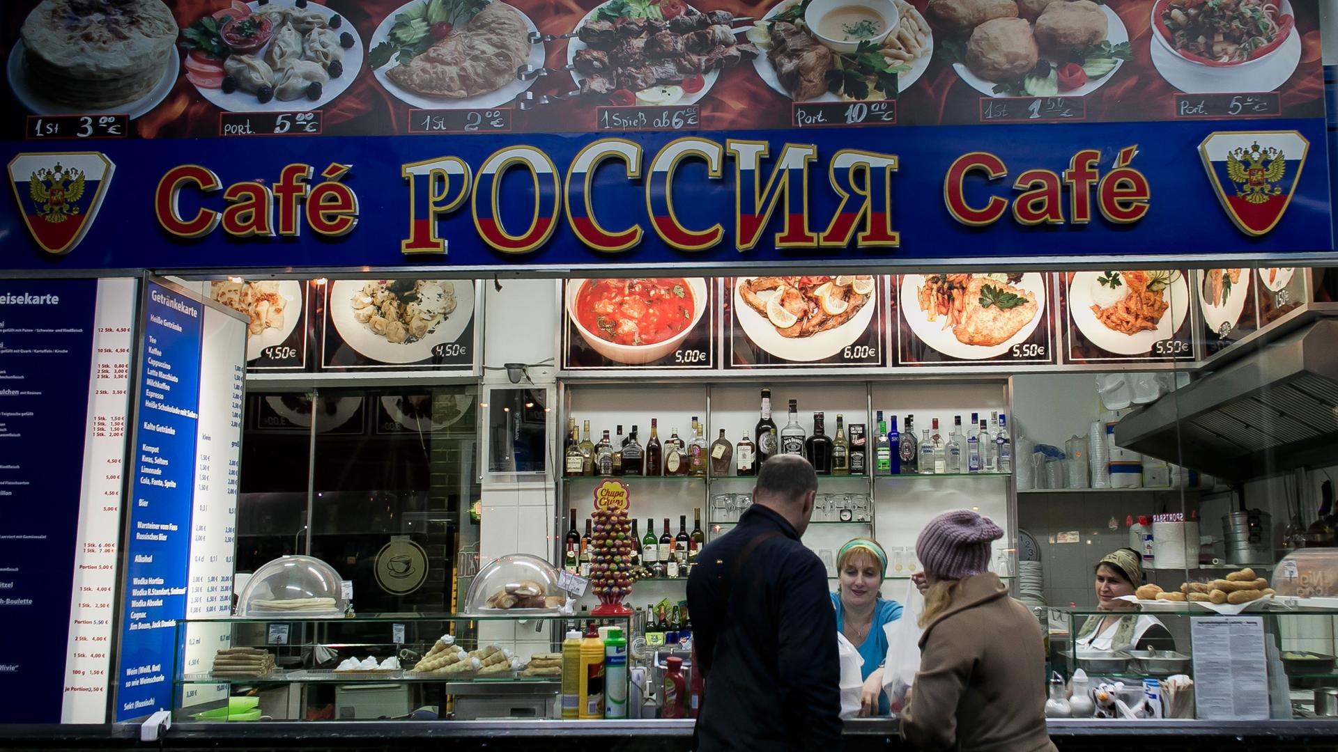 Eine Frau bedient Kunden in einem russischen Imbiss im Berliner Bezirk Charlottenburg.