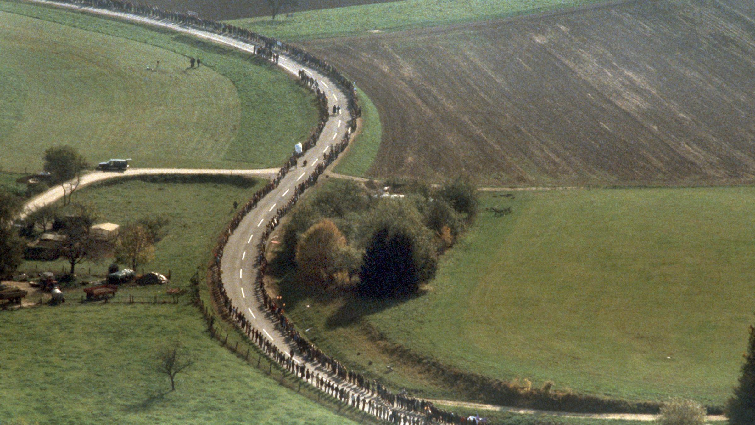 Luftbild der Menschenkette am 22.10.1983 auf der BundesstraÃe 10 zwischen Plochingen und Ulm. (Luftbildfreigabe Nr. 000 B 27327, Regierungspräsident Stuttgart). Im Rahmen der von der Friedensbewegung initiierten "Aktionswoche" gegen die Stationierung neuer Nato-Mittelstreckenraketen in Europa bildeten Tausende von Demonstranten eine Menschenkette von den amerikanischen Wiley-Barracks in Neu-Ulm bis nach Stuttgart. 