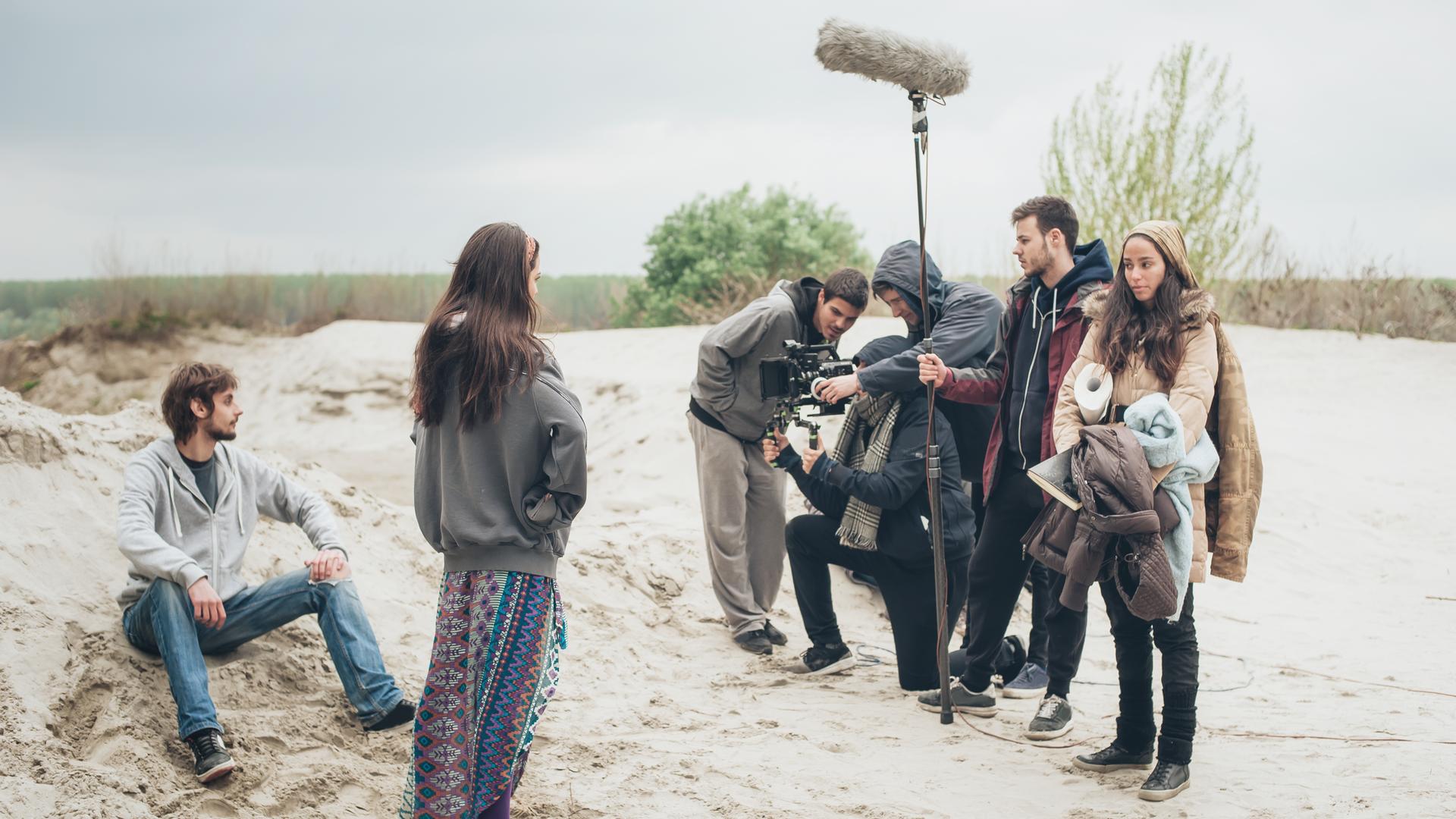 Filmteam beim Drehen einer Filmszene mit einem Paar im Freien. Filmteam beim Drehen einer Filmszene mit einem Paar im Freien.