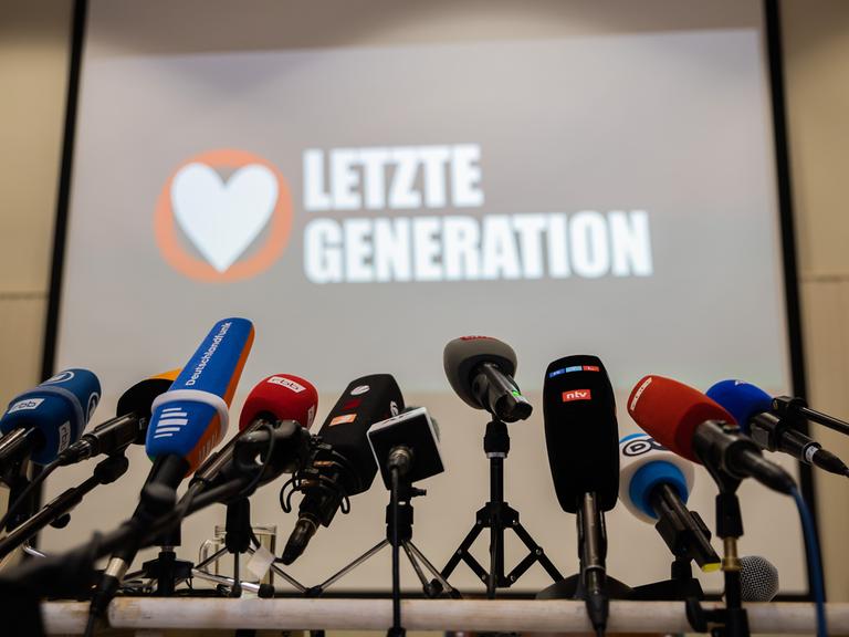 Mikrofone stehen vor Beginn einer Pressekonferenz der Letzten Generation in der Reformationskirche in Berlin-Moabit auf einem Tisch. Polizei und Staatsanwaltschaft haben im Zuge eines Ermittlungsverfahrens zu Mitgliedern der Letzten Generation 15 Objekte in sieben Bundesländern durchsucht.