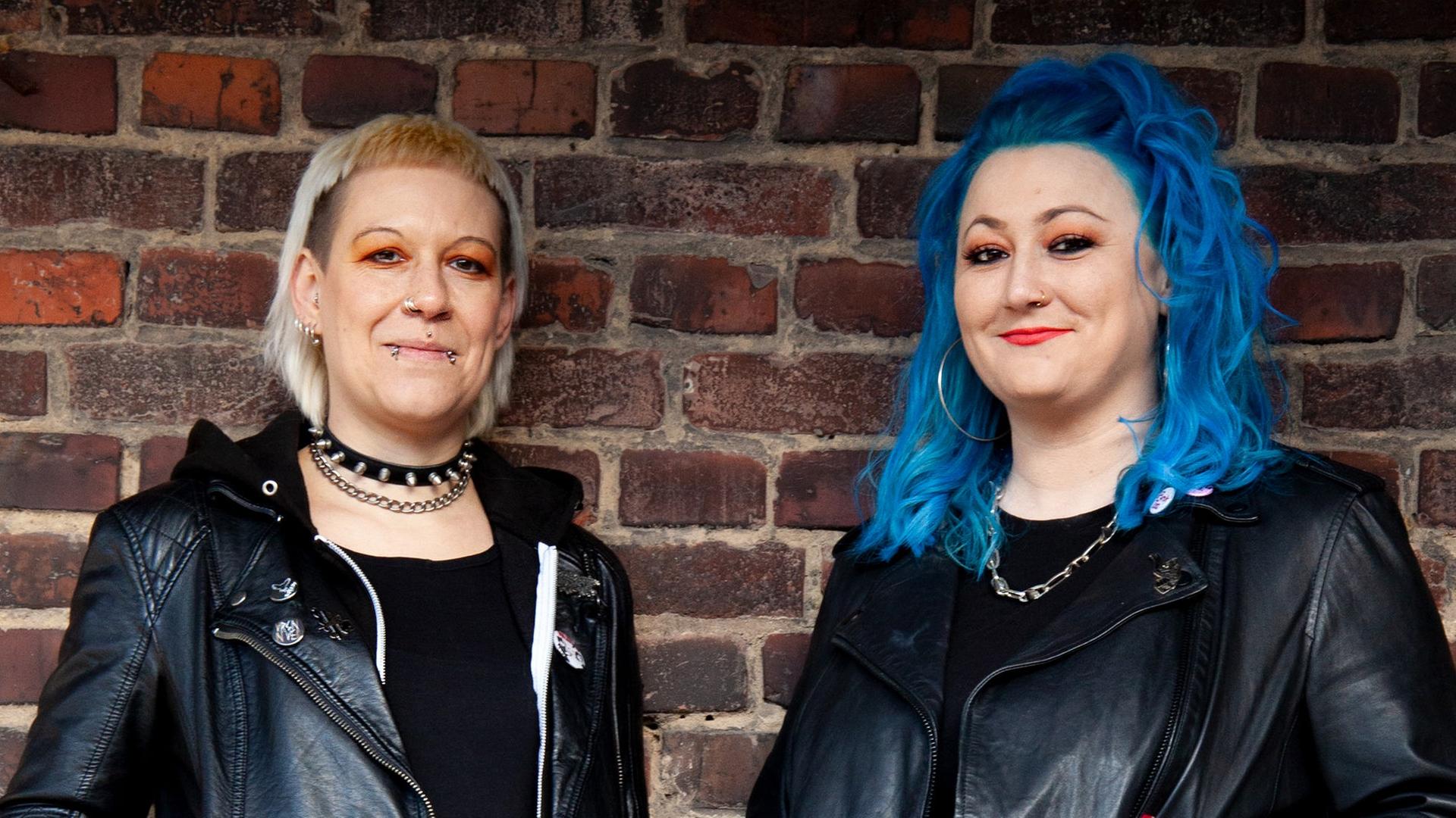 Diana Ringelsiep und Ronja Schwikowski stehen in punk-typischer Aufmachung vor einer Backsteinmauer und schauen in die Kamera. Diana Ringelsiep und Ronja Schwikowski stehen in punk-typischer Aufmachung vor einer Backsteinmauer und schauen in die Kamera.