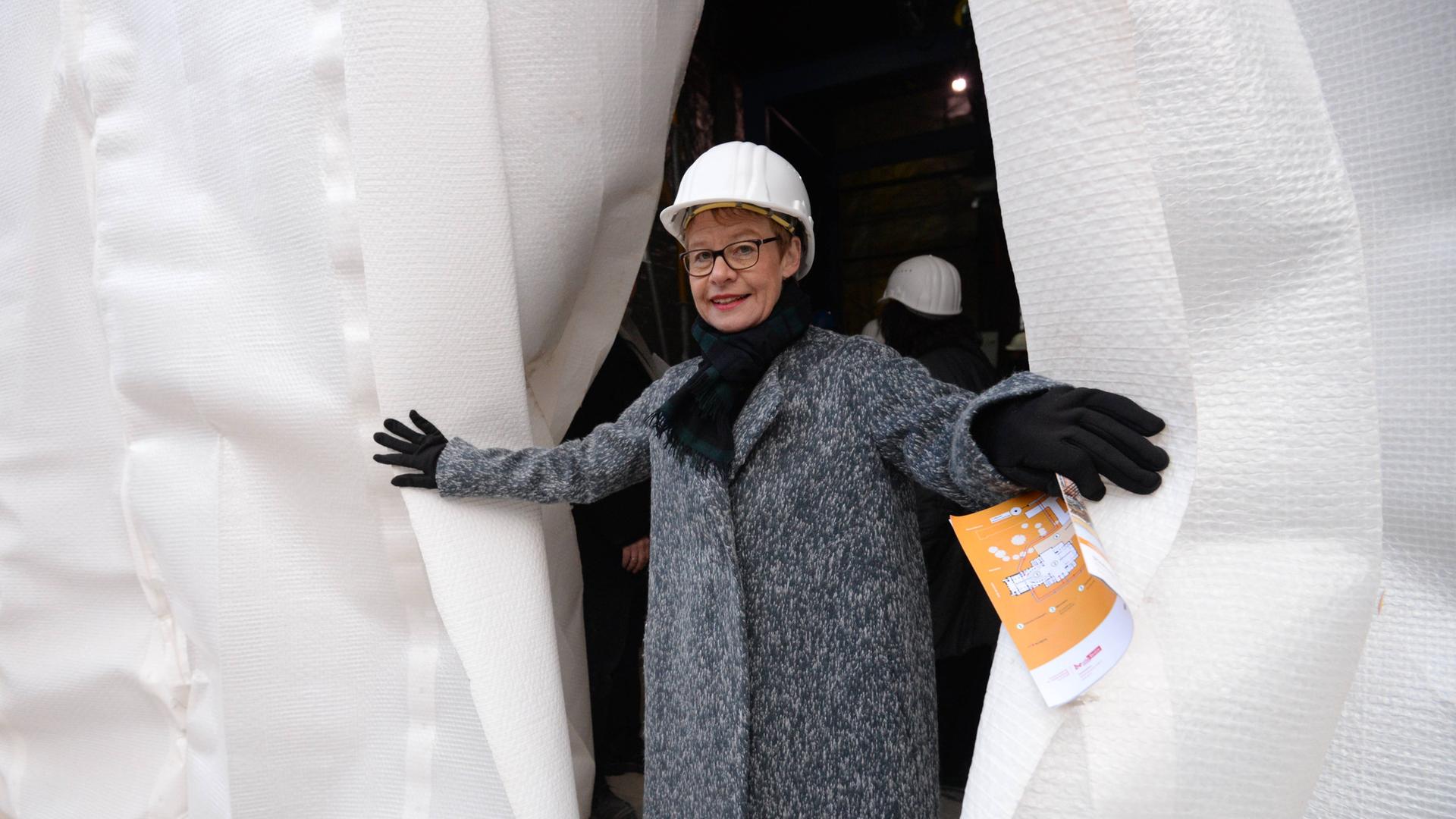 Die ehemalige Senatsbaudirektorin Regula Lüscher mit Bauarbeiterhelm schaut hinter einem Vorhang hervor anläßlich des Beginns der Sanierung der Staatsoper Unter den Linden im Dezember 2014. Die ehemalige Senatsbaudirektorin Regula Lüscher mit Bauarbeiterhelm schaut hinter einem Vorhang hervor anläßlich des Beginns der Sanierung der Staatsoper Unter den Linden im Dezember 2014.